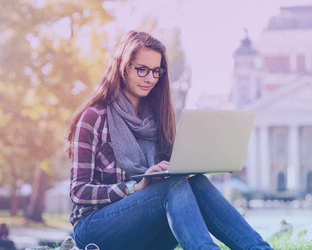 Image of a female college student sitting on campus learning about the different career clusters after completing virtualjobshadow.com’s career assessment.