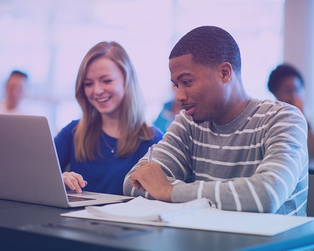 Image of high school students in front of a laptop working together on a career exploration project in their career and technical education class.